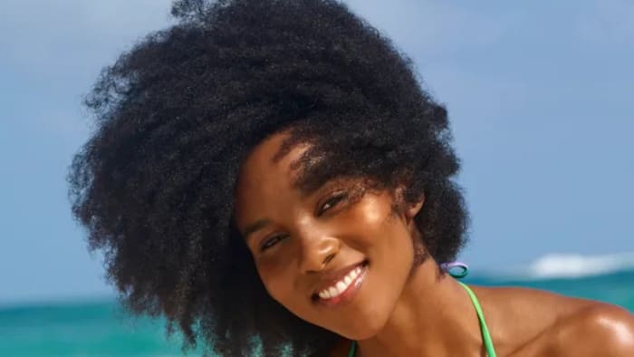 Drew Dorsey poses in front of the ocean and smiles widely at the camera.